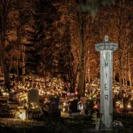 Cmentarz o zmierzchu rozświetlony setkami zniczy
