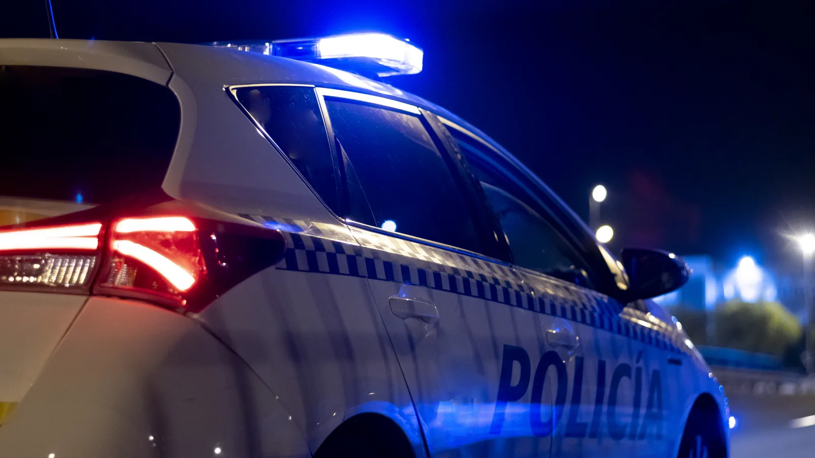 Radiowóz polskiej policji z włączonymi niebieskimi światłami nocą