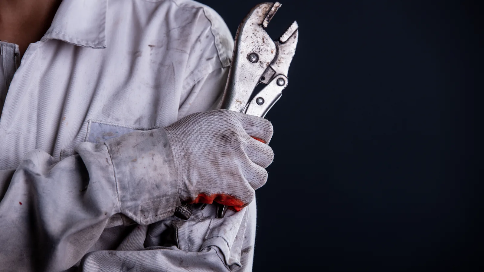 Mechanik w mundurze roboczym trzymający klucz